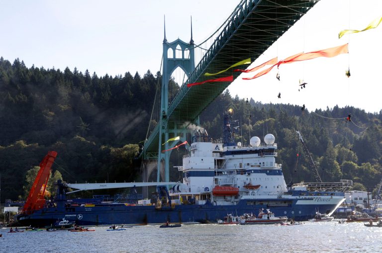 In this July 30, 2015, file photo, the Royal Dutch Shell PLC icebreaker Fennica heads up the Willamette River under protesters hanging from the St. Johns Bridge on its way to Alaska in Portland, Ore. (AP Photo/Don Ryan)