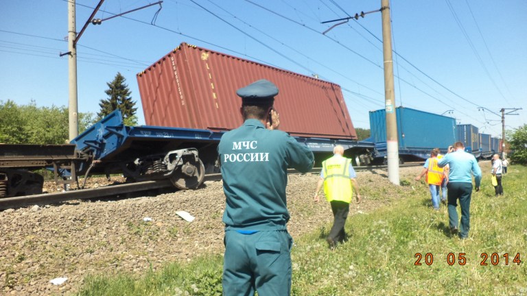 In this Tuesday, May 20, 2014 photo provided by the Russian Ministry for Emergency Situations for Moscow region, ministry employee uses a mobile phone at the site of train collision near the city of Naro-Fominsk outside Moscow. The Interior Ministry said the accident happened when several cars of a cargo train derailed and hit a passenger train near Naro-Fominsk, a town 50 kilometers (30 miles) southwest of Moscow. (AP Photo/ Ministry for Emergency Situations Press Service)