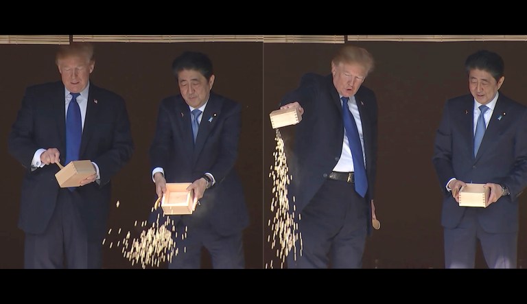 The president and the prime minister both spooned in their feed a little at a time. Abe then dumped the rest of his box into the pond. Trump followed suit, spooning just a little at first, and then dumping out the remnants of his box into the pond. (AP Photos)