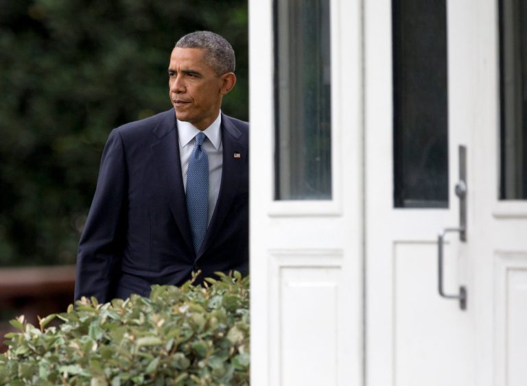 President Barack Obama walks from behind a guard shack and across the South Lawn of the White House in Washington, Friday. (AP Photo/Carolyn Kaster)