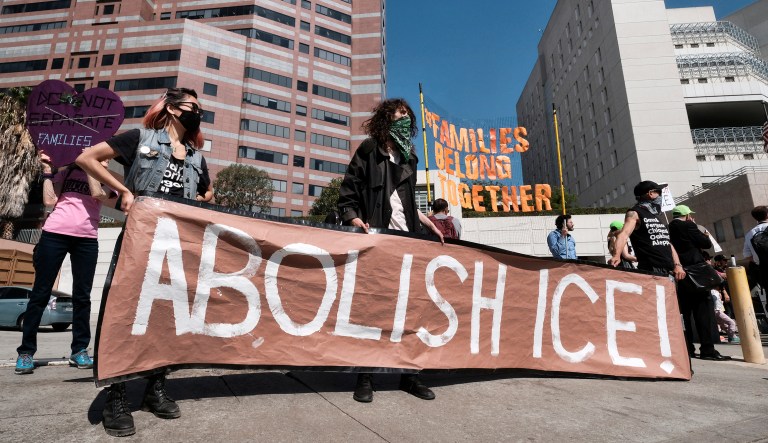 Protesters display a sign that reads "Abolish ICE" during a rally in front of the Immigration and Customs Enforcement facility in downtown Los Angeles on Monday, July 2, 2018. Protesters who were blocking the entrance to an Immigration and Customs Enforcement facility in downtown Los Angeles have been led away in handcuffs. A group of 17 protesters sat down in the street, blocking the entrance to the facility Monday morning. The protesters, including faith and community leaders, locked arms and chanted, "Shut down ICE!"