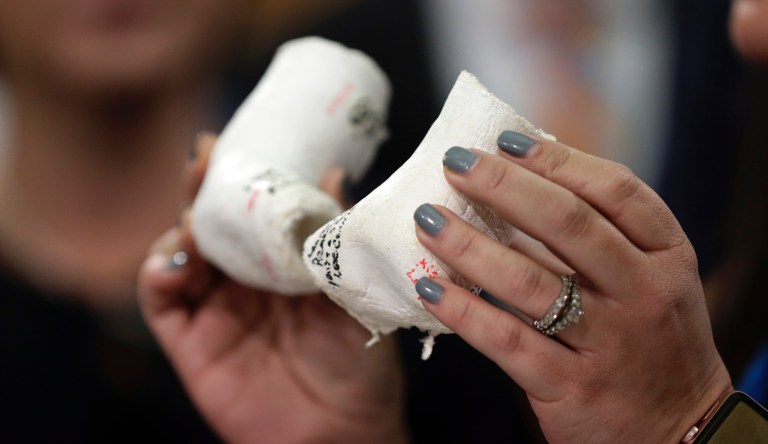 Claire Cullwell, holds casts and braces she wore as a newborn as she stands with Texas lawmakers and talks about the Texas Born-Alive bill, Thursday, March 7, 2019, in Austin, Texas. 