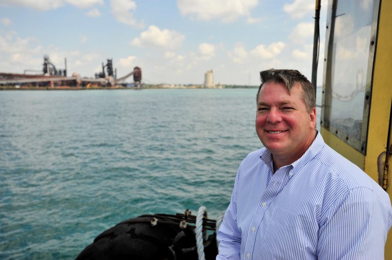 In this July 14, 2014 photo, Detroit-Windsor Truck Ferry owner Gregg Ward rides on the truck ferry across the Detroit River in Detroit. For two decades, Gregg Ward and his father, John Ward, have run a plucky, small but important freight operation, carrying trucks with hazardous or oversized cargo banned from the Ambassador Bridge by law. (AP Photo/Detroit News, Robin Buckson)  DETROIT FREE PRESS OUT; HUFFINGTON POST OUT