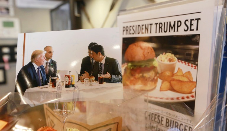 President Trump and Japanese Prime Minister Shinzo Abe, right, ate a lunch of hamburgers from Munch's Burger Shack at Kasumigaseki Country Club in Tokyo. The cheeseburger Trump had is still drawing lines at the Tokyo burger joint. (AP Photo/Eugene Hoshiko)