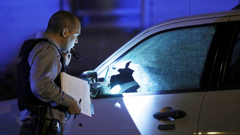 A police detective inspects an SUV that was damaged by bullets at a crime scene in Chicago on Sept. 3. Gun violence is a leading cause of death for African Americans ages 1 to 44. While African Americans comprise approximately 13 percent of the U.S. population, they experience nearly 24 percent of all firearm deaths and more than 54 percent of all firearm homicides. (John J. Kim/Chicago Tribune via AP)