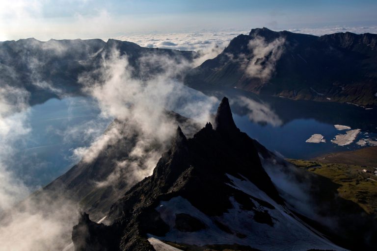 In this Wednesday, June 18, 2014 photo, clouds float over the peak of Mt. Paektu in North Korea's Ryanggang province. More than a thousand years ago, a huge volcano straddling the border between North Korea and China was the site of one of the biggest eruptions in human history, blanketing eastern Asia in its ash. But unlike other major volcanos around the world, the remote and politically sensitive Mount Paektu remains almost a complete mystery to foreign scientists who have - until recently - been unable to conduct on-site studies. (AP Photo/David Guttenfelder)