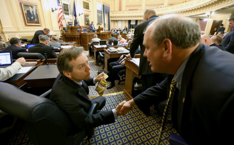 Del. S. Chris Jones, R-Suffolk, left, chairman of the House Appropriations committee, shakes hands with the committee chief of staff, Robert Vaughn, right, after the budget was approved by the House of Delegates at the State Capitol in Richmond, VA Thursday, June 12, 2014. (AP Photo/Richmond Times-Dispatch, Bob Brown).