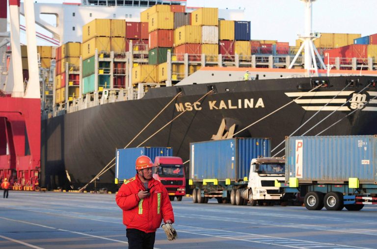 FILE - In this Tuesday, April 8, 2014 file photo, a worker walks past a container vessel docked in Qingdao port in east China's Shandong province. China's economic growth slowed to 7.4 percent in the first quarter, raising the risk of job losses and a potential impact on its trading partners. The figure reported Wednesday, April 16 by the government was down from the previous quarter's 7.7 percent. (AP Photo/File) CHINA OUT