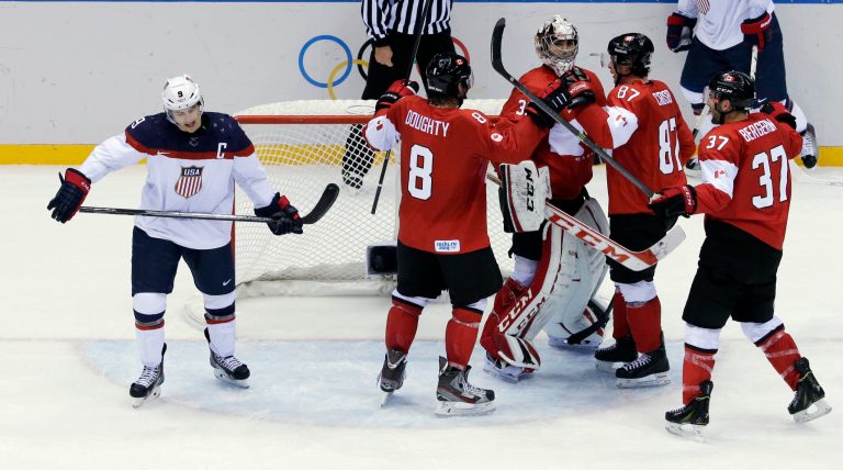 USA forward Zach Parise skates off the ice as Canadian players celebrate after a men's semifinal ice hockey game at the 2014 Winter Olympics, Friday, in Sochi, Russia. Canada won 1-0 to advance to the gold medal game. (AP/David J. Phillip )