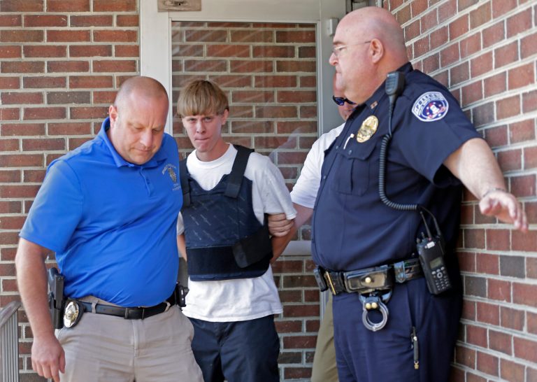 Charleston, S.C., shooting suspect Dylann Storm Roof, center, is escorted from the Shelby Police Department in Shelby, N.C., Thursday, June 18, 2015. Roof is a suspect in the shooting of several people Wednesday night at the historic Emanuel African Methodist Episcopal Church in Charleston, S.C. (AP Photo/Chuck Burton)
