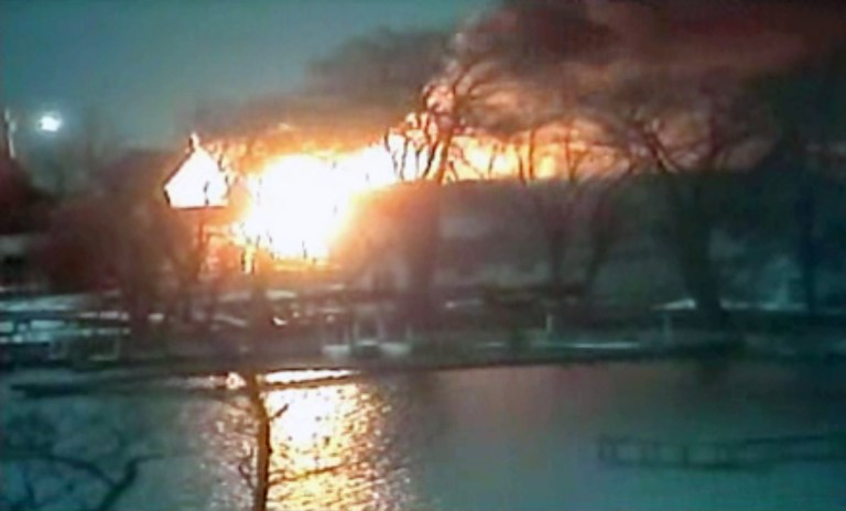   This image taken from video provided by WHAM13-TV, shows a wide view of homes on fire in an area where a gunman ambushed four volunteer firefighters responding to an intense pre-dawn house fire early Monday, Dec. 24, 2012, in Webster, N.Y., killing two before ending up dead himself, authorities said. Police used an armored vehicle to evacuate more than 30 nearby residents. (AP Photo/WHAM13-TV via AP video)  