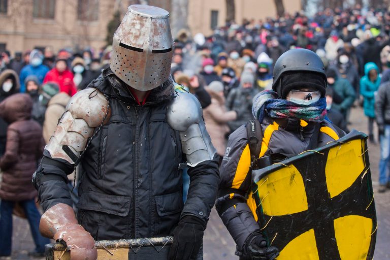 FILE - In this file photo taken on Monday, Jan.  20, 2014, Protesters clad in improvised protective gear prepare for a clash with police in central Kiev, Ukraine. Protesters in Kiev used improvised protective gear to protect themselves from stun grenades, rubber bullets and tear gas during clashes with police in central Kiev this week? After a night of vicious streets battles, anti-government protesters and police clashed anew Monday in the Ukrainian capital Kiev. (AP Photo/Evgeny Feldman, file)