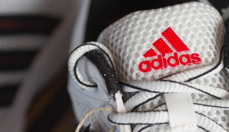 Fuerth, Germany - October 19, 2011: Red Adidas logo on a white nylon running shoe.Adidas AG is one of the leading sports apparel manufacturer in the world with their headquarter in Herzogenaurach, Germany. Adidas is also famous for its distinctive three stripes on the majority of all products.