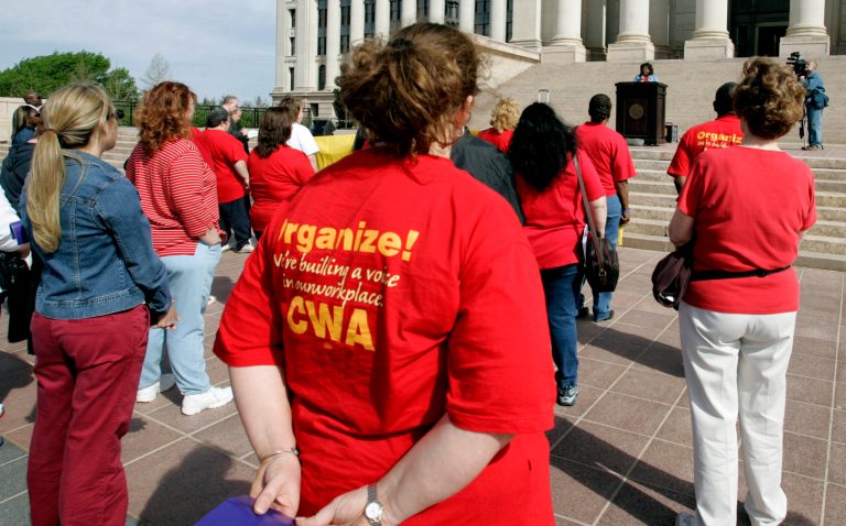 A crowd listens to Sharon Reed, at podium, president of Communications Workers of America local 6086, at a rally at the state Capitol in Oklahoma City, Tuesday, April 11, 2006. (AP Photo)
