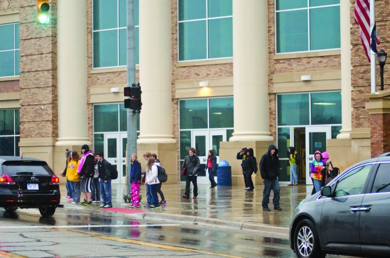 Battle Creek Central High School students wait to cross Van Buren Ave., after school ended for the day Thursday, Dec. 20, 2012 in Battle Creek, Mich. Dozens of Michigan schools canceled classes for thousands of students to cool off rumored threats of violence and problems related to doomsday scenarios based on the Mayan calendar, officials said Thursday. (AP Photo/Battle Creek Enquirer, Robert Youngs Jr.)