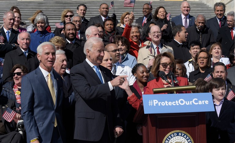 As House Minority Leader Nancy Pelosi of Calif., speaks, right, former Vice President Joe Biden, center, points to the crowd on Capitol Hill in Washington, Wednesday, March 22, 2017, during an event marking seven years since former President Barack Obama signed the Affordable Care Act into law. (AP Photo/Susan Walsh)