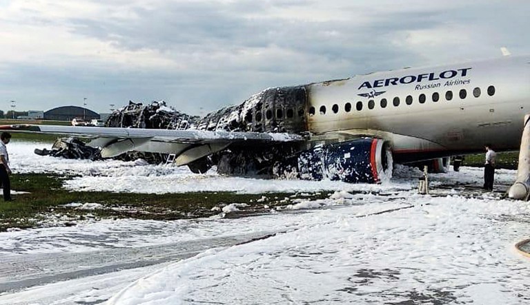 The Sukhoi SSJ100 aircraft of Aeroflot airlines is covered in fire retardant foam after an emergency landing in Sheremetyevo airport in Moscow, Russia, Sunday, May 5, 2019. Scores of people died when the Aeroflot airliner burst into flames while making the emergency landing at the airport Sunday evening, officials said.