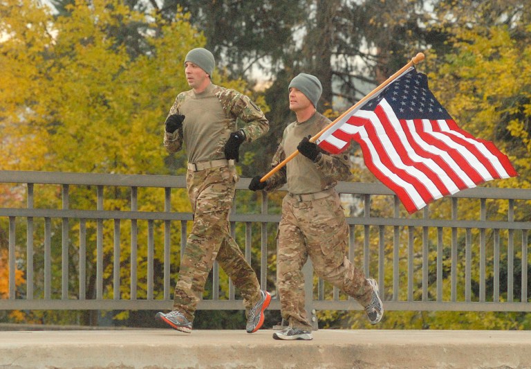 Les Rose, left, and Jay Via, who served in Afghanistan at different times, decided to run more than 13 miles with an American flag Monday in Troy, Ohio. (AP/Anthony Weber)