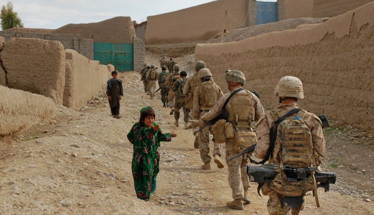 In this Saturday, Feb. 19, 2011, photo, U.S. Marines from 3rd Platoon, India Company, 3rd Battalion, 5th Marine Regiment walk past children asking for candy while on patrol in Sangin district southern Helmand province of Afghanistan. The cacophony of gunfire and bombing that dominated this southern river valley in the fall has dropped to a whisper, but U.S. Marines who have paid a heavy price battling the Taliban in Afghanistan's deadliest spot expect the insurgents to hit back hard.