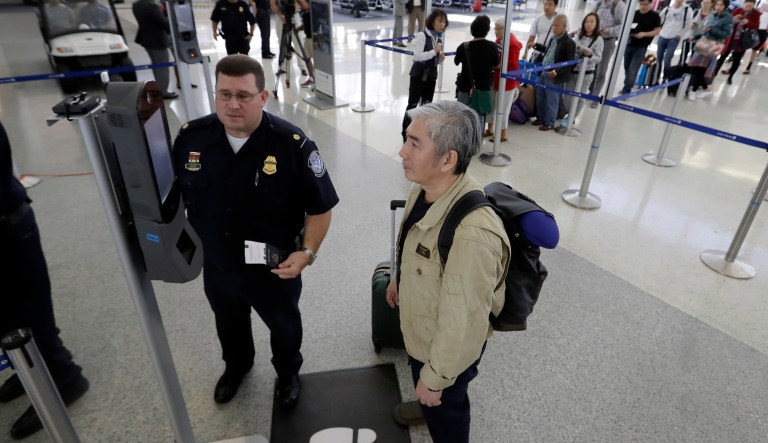 U.S. Customs and Border Protection supervisor Erik Gordon, left, helps a passenger navigate one of the new facial recognition kiosks at a United Airlines gate before boarding a flight to Tokyo, Wednesday, July 12, 2017, at George Bush Intercontinental Airport, in Houston.