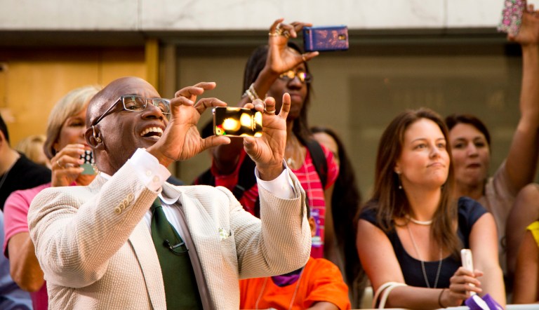 Al Roker takes photos during the Lionel Richie performance on NBC's "Today" show on Thursday, Aug. 16, 2012 in New York.