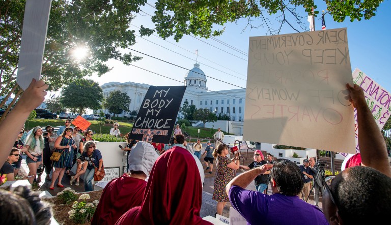 Lucia Hermo, with megaphone, leads chants during a rally against a ban on nearly all abortions, outside of the Alabama State House in Montgomery, Ala., on Tuesday, May 14, 2019.