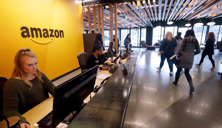Employees walk through a lobby at Amazon's headquarters Tuesday, Nov. 13, 2018, in Seattle. Amazon, which is growing too big for its Seattle hometown, is spreading out to the East Coast. The online shopping giant ended its 14-month-long competition for a second headquarters Tuesday by selecting New York and Arlington, Va., as the joint winners.