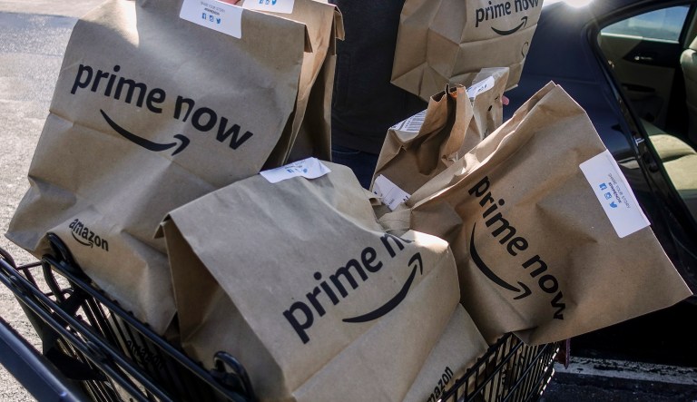 Amazon Prime Now bags full of groceries are loaded for delivery by a part-time worker outside a Whole Foods store, Thursday, Feb. 8, 2018, in Cincinnati.
