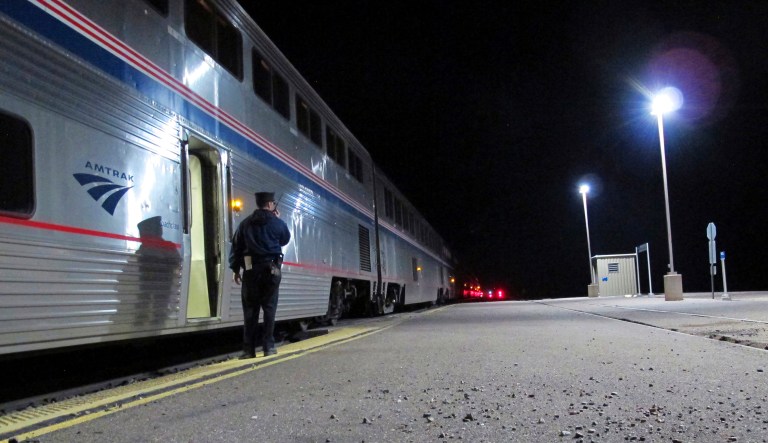 In this Friday, Dec. 29, 2017 photo, an Amtrak employee signals that all passengers are clear as the train departs the Williams Junction station outside Williams, Ariz. Service at the Williams Junction station ended Monday, Jan. 1, 2018. Passengers now are dropped off and picked up in downtown Flagstaff.