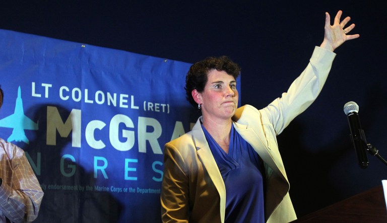 Amy McGrath, right, with her husband, Erik Henderson, waves to supporters after being elected as the Democratic candidate for Kentucky's 6th Congressional District, Tuesday, May 22, 2018, in Richmond, Ky.