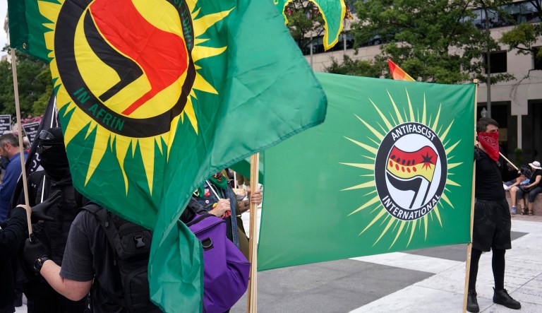 Counter-protesters hold Anti-Fascist (Antifa) flags ahead of the Unite the Right 2 rally in Washington, D.C., U.S., on Sunday, Aug. 12, 2018. The rally, being held in Lafayette Park near White House, marks the one-year anniversary of the Charlottesville, Virginia, rally where a car driven into a crowd of counter protesters killed 32-year-old Heather Heyer.