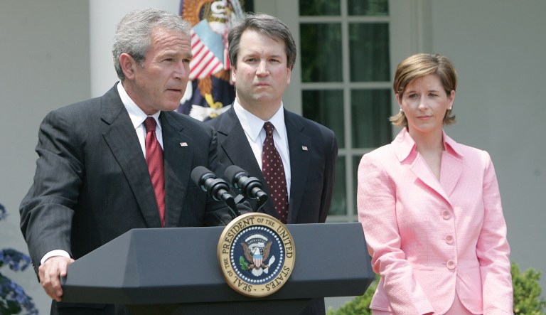 President Bush, speaks in the Rose Garden of the White House before the swearing-in of Brett Kavanaugh, center, as Judge for the U.S. Court of Appeals for the District of Columbia Thursday, June 1, 2006 in Washington. Holding the Bible is Kavanaugh's wife Ashely Kavanaugh.