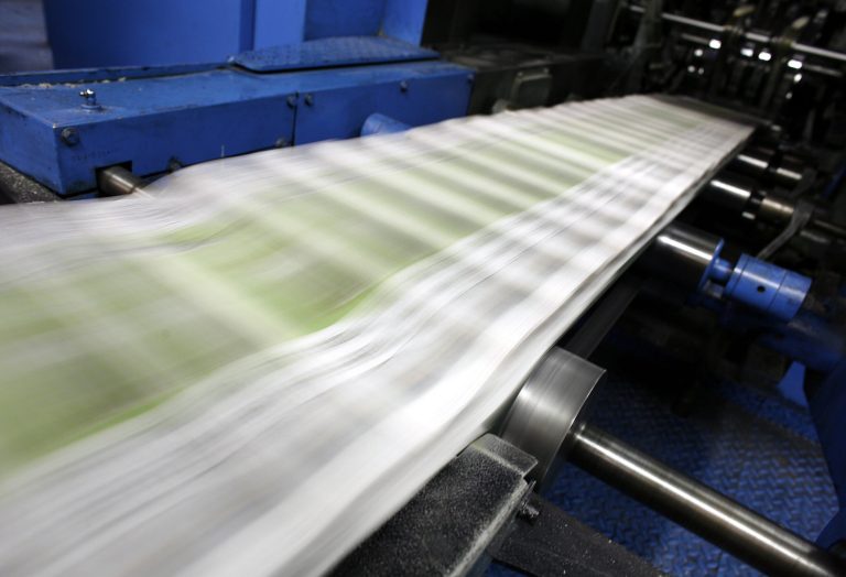 In this 2006 photo, pictures and words shoot past in a blur at the New York Post's printing plant in the Bronx borough of New York.