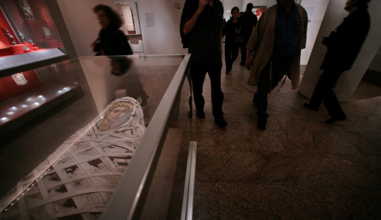 An Egyptian mummy with a painted face, lies in a glass encasement at the Metropolitan Museum of Art, New York, Wednesday Nov. 14, 2007.