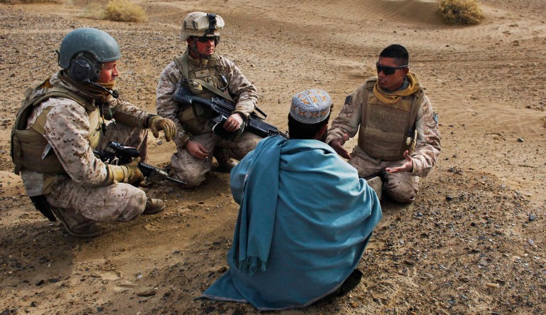 United States Marine Sgt. Isaac Tate, left, and  Cpl. Aleksander Aleksandrov , center, interview a local Afghan man with the help of a translator from the 2nd MEB, 4th Light Armored Reconnaissance Battalion on a patrol in Qwual-e-now, in the volatile Helmand province of southern Afghanistan, Friday, Dec. 11, 2009. 