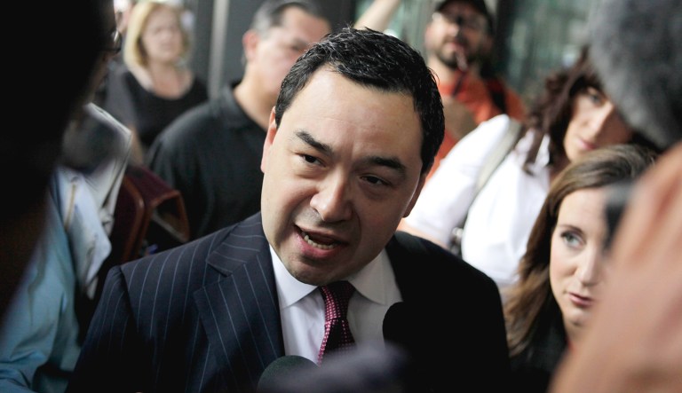 Miguel Estrada leaves a federal courthouse surrounded by members of the media.