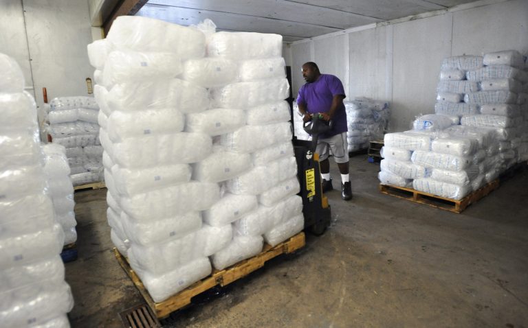 In this July 27, 2011 photo, Michael Frasier transports bags of ice at his job in New Haven, Conn.  Frasier, who has been in and out of prison most of his adult life, found employment with help of a prison re-entry program in New Haven. 