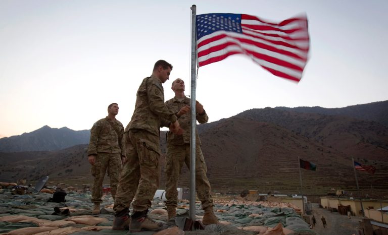 Capt. Erik Schutz, 26, of Medina, Minn., right, and Capt. Matt Schachman, 28, of Wilmette, Ill., with the U.S. Army's 25th Infantry Division, 3rd Brigade Combat Team, 2nd Battalion 27th Infantry Regiment raise a new American flag to commemorate the 10th anniversary of the 9/11 attacks as Capt. Ron Hopkins, 27, left, looks on Sept. 11, 2011 at Forward Operating Base Bostick in Kunar province, Afghanistan. 