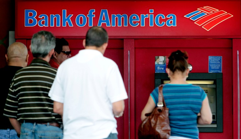 This photo taken Friday, Oct. 14, 2011, shows customers in line at a Bank of America ATM in Hialeah, Fla.