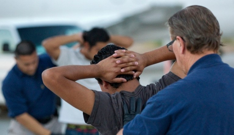 Illegal immigrants from El Salvador are searched prior to boarding an MD-80 aircraft for a repatriation flight of 80 illegal immigrants back to their home country, June 26, 2012, at Phoenix-Mesa Gateway Airport in Mesa, Ariz.