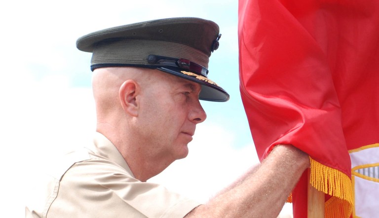 Lt. Gen. David Berger holds a flag.