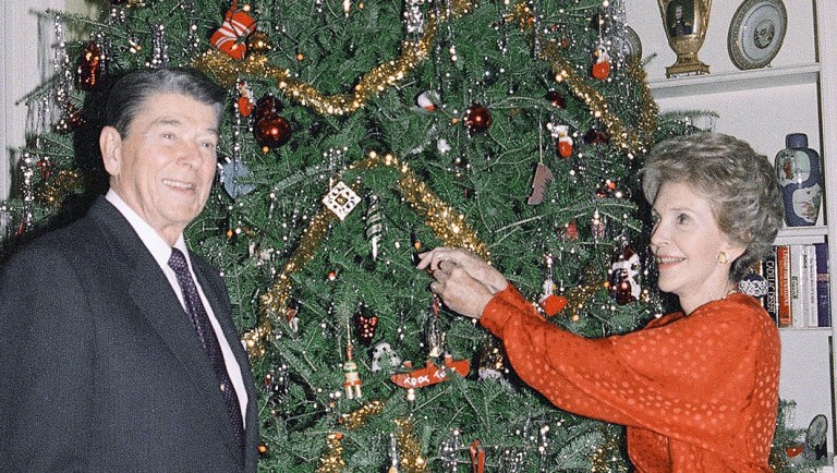 President Ronald Reagan and first lady Nancy Reagan pose next to their Christmas tree.