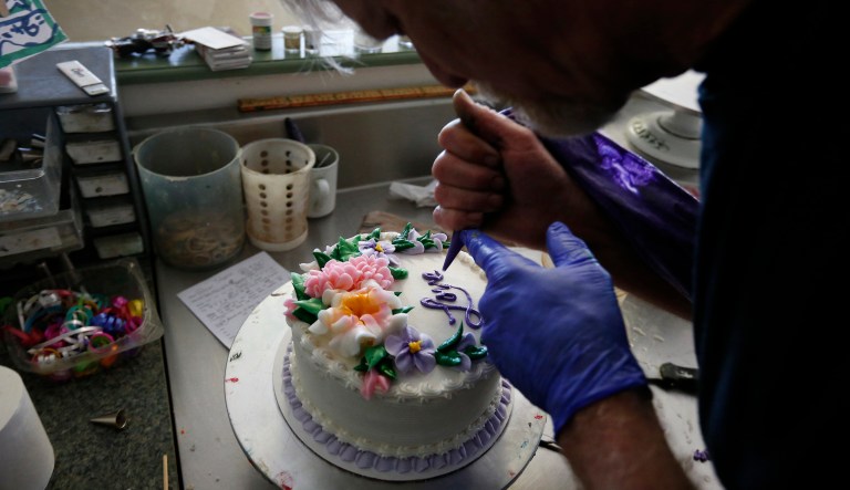 In this March 10, 2014, photo, Masterpiece Cakeshop owner Jack Phillips decorates a cake inside his store, in Lakewood, Colo.