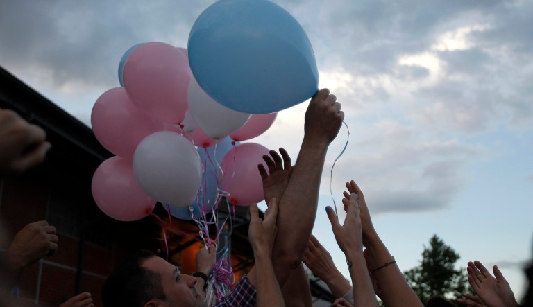 A man share balloons with helium to the people during a sunset, in northern Greek city of Thessaloniki on Saturday, May 31, 2014.