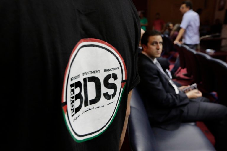 FILE - In this Monday, April 20, 2015 file photo, an Egyptian wears a T-shirt with a logo of BDS (boycott, divestment and sanctions), a campaign started by Palestinian activists to boycott Israel and Israeli-made goods, during the launch of its campaign at the Egyptian Journalists' Syndicate in Cairo, Egypt. The group calls for a global boycott campaign against Israel as a nonviolent method to promote the Palestinian struggle for independence.