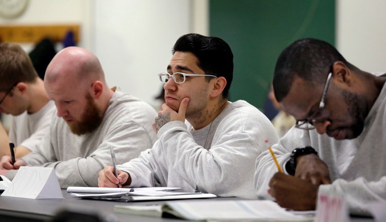 Rudy Madrigal, center, looks on as he sits with fellow inmates in a college world history class at the Monroe Correctional Complex in Monroe, Wash.