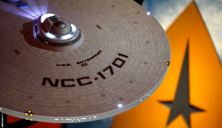 In this photo taken Wednesday, May 18, 2016, a model of the USS Enterprise (NCC-1701) hangs above an exhibit for a 50th anniversary celebration of the Star Trek television show and films at the EMP Museum, in Seattle. "Star Trek: Exploring New Worlds"ï¿½ opens Saturday, May 21, and is filled with geeky artifacts from all the Star Trek series and movies, and also illustrates how Star Trek was both a reflection of its times and a catalyst for social change--from a starring role by a black actress to a Russian actor featured during the Cold War and interracial and same sex relationships.
