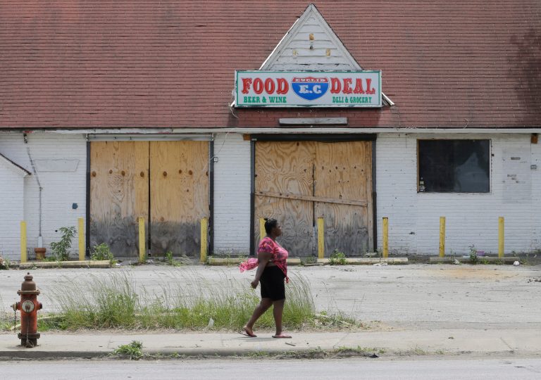 A woman walks past a closed-down business in East Cleveland, Ohio.
