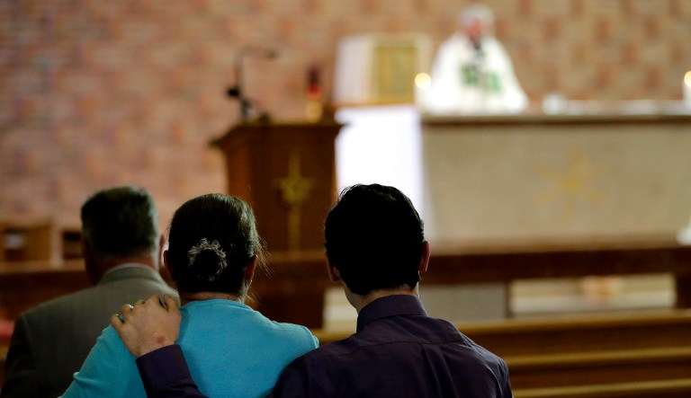 Parishioners sit in the pews during a Mass.