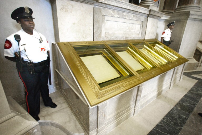 Guards stand next to the U.S. Constitution in the Rotunda of the National Archives in Washington.